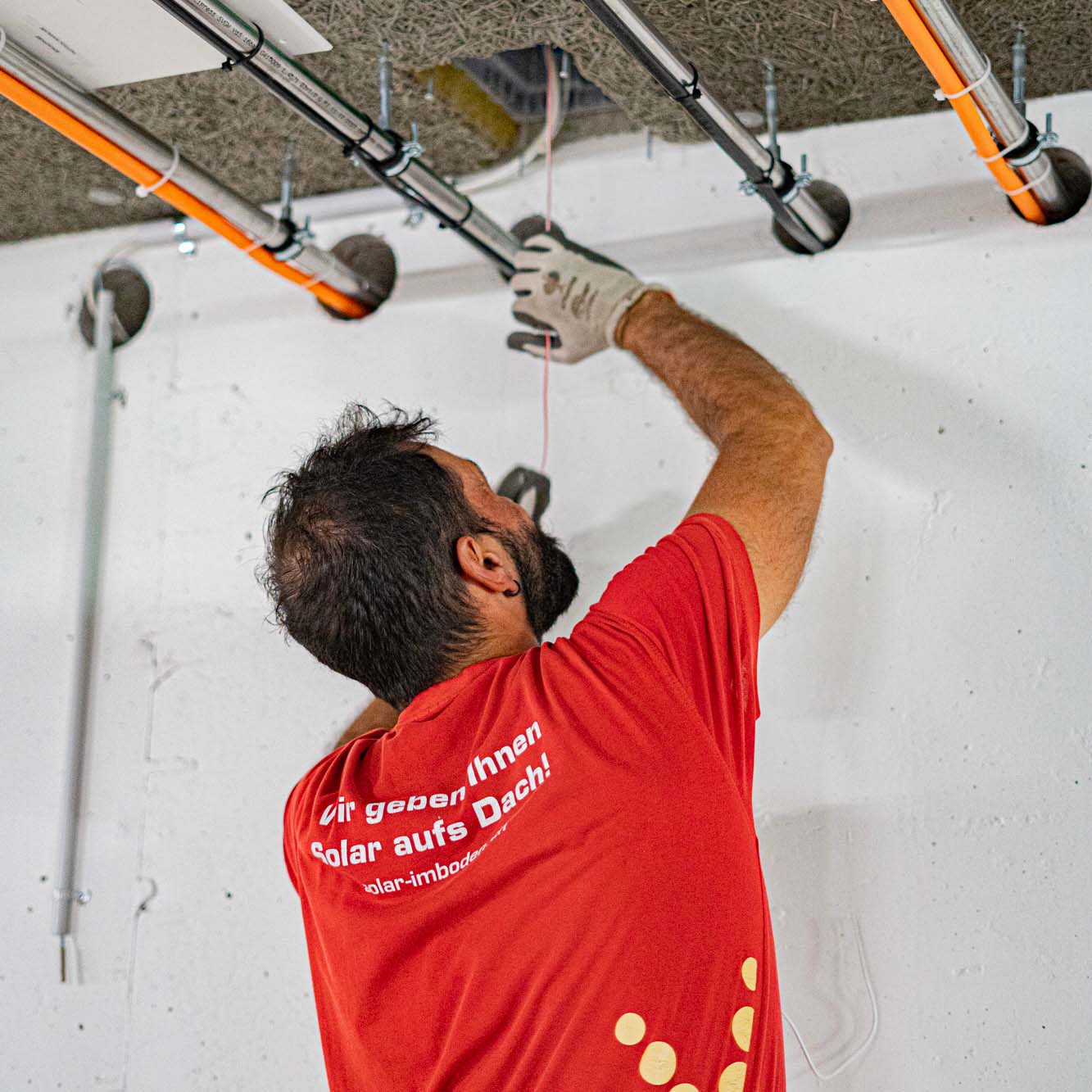 Elektriker montiert Kabelrohre an der Decke